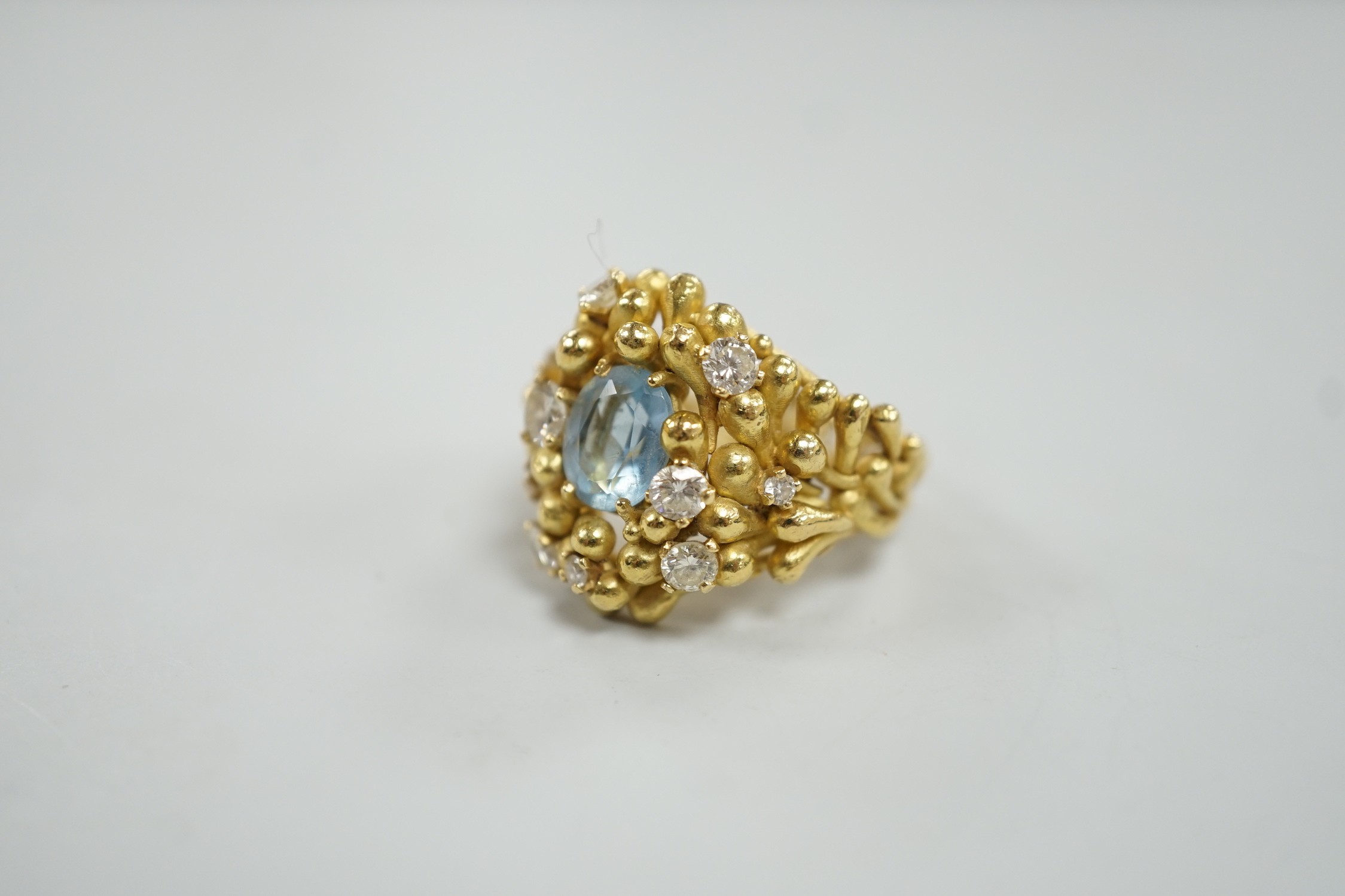An early 1970's modernist 18ct gold, aquamarine and diamond cluster set dress ring, maker HB or AB? in italics, size O/P, gross weight 16.8 grams.